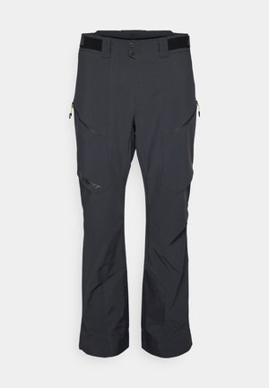 Pantalones exteriores negros confeccionados con tejido duradero, que cuentan con múltiples bolsillos con cremallera, rodillas reforzadas y una cinturilla ajustable.