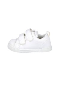Zapatillas blancas para niños con dos correas de velcro, punta redondeada, suela de goma texturizada y material suave parecido al cuero. Nombre de la marca en el lateral.