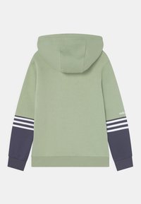 Grön huva sweatshirt med marinblå ärmar, som har tre vita ränder och logodetaljer. Mjuk material, avslappnad passform, ribbade ärmslut.