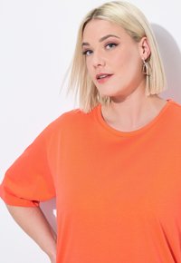 Bright orange short-sleeve t-shirt with a round neckline, made of soft fabric, featuring a loose fit and casual design.