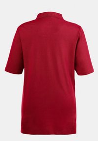 Maglietta polo rossa con colletto e maniche corte; realizzata in tessuto liscio, caratterizzata da un colore uniforme e un design a vestibilità rilassata.
