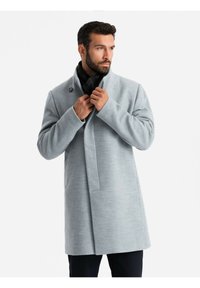 Cappotto grigio chiaro con colletto alto, chiusura a un solo bottone e maniche lunghe. Texture liscia, design fino al ginocchio e silhouette dritta.