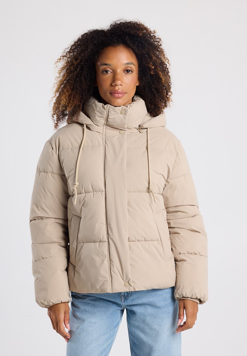 Giubbotto imbottito di un beige chiaro con colletto alto, cappuccio con cordoncino e design trapuntato. Presenta una chiusura frontale a pressione e tasche laterali.