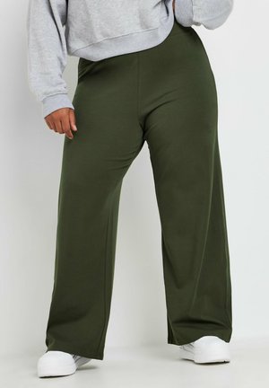 Pantalones de chándal de pierna ancha en verde bosque, hechos de una tela suave con una textura lisa. Cuentan con una cinturilla elástica y detalles de costura lateral.