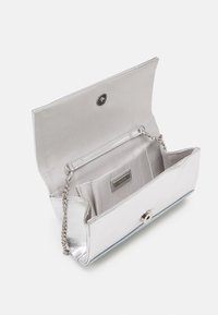 Geantă de mână metalică argintie, cu o textură netedă, având un șnur de lanț, închidere tip snap și mai multe compartimente interioare.