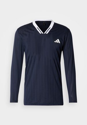 Marineblaue Sportlangarmshirt mit weißem V-Ausschnitt, vertikalen Streifen und einem weißen Logoakzent auf der Brust. Glatter, leichter Stoff.