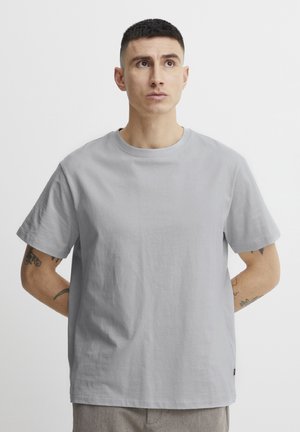 Grijs katoenen t-shirt met een ronde halslijn en korte mouwen; heeft een zachte textuur en een relaxte pasvorm. Subtiel logo detail aan de zoom.