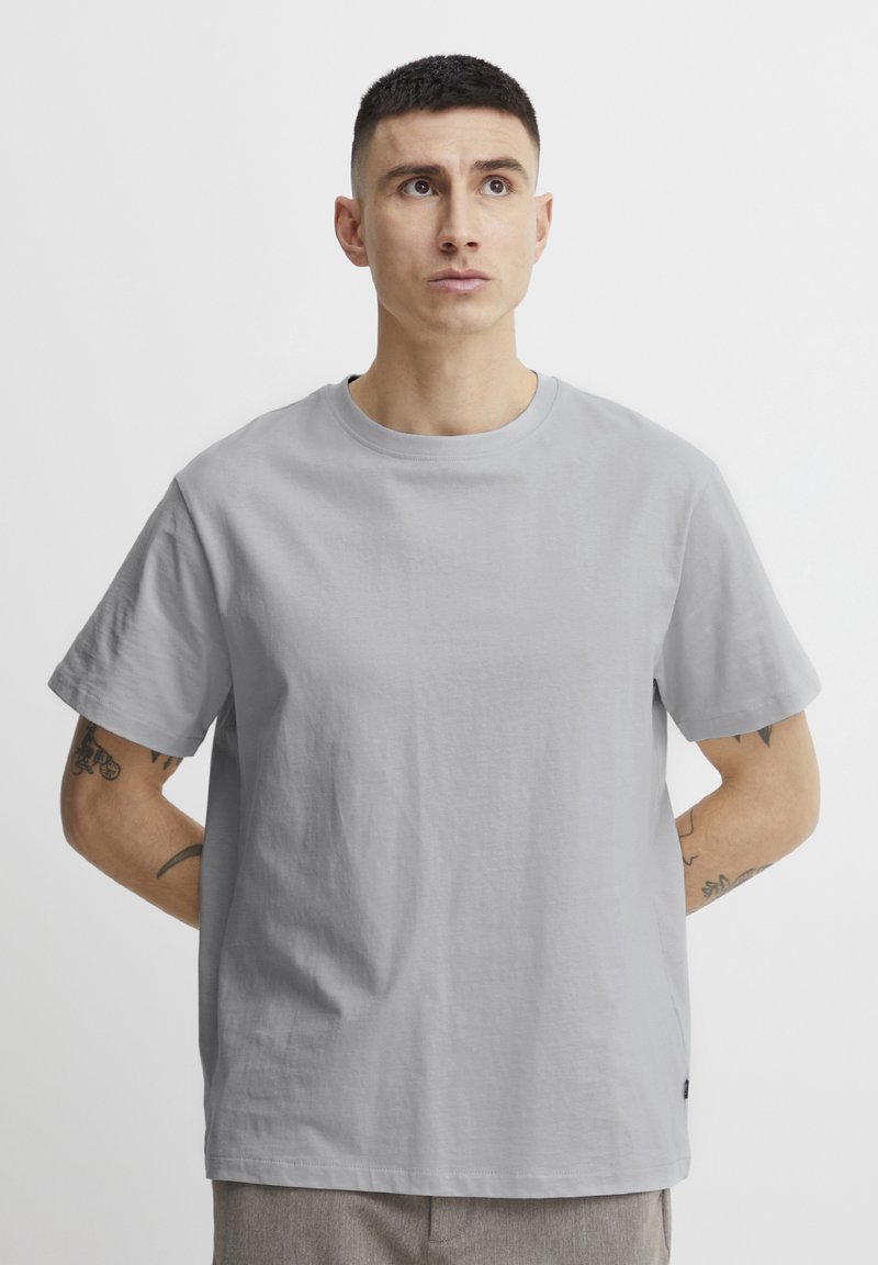 Grijs katoenen t-shirt met een ronde halslijn en korte mouwen; heeft een zachte textuur en een relaxte pasvorm. Subtiel logo detail aan de zoom.