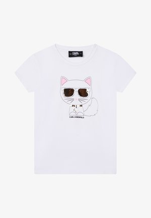 Biała koszulka dziecięca z kreskówkowym kotem w odblaskowych okularach przeciwsłonecznych i obroży, pod kotem nazwa marki „Karl Lagerfeld“.