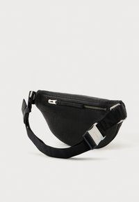 Pochete de couro preta com acabamento texturizado, bolso com fecho e uma alça preta em contraste com uma fivela prateada.