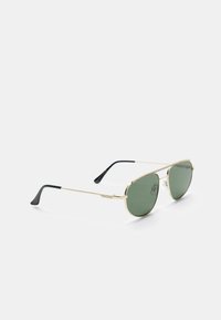 Occhiali da sole con montatura in metallo dorato e lenti verdi. Presentano una forma rotonda, un design elegante e dettagli neri sulle aste.