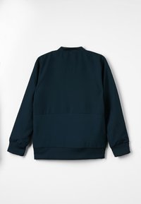 Mørk navy blå bomberjakke med lange ærmer, ribbede manchetter og ribbet kant, vist fra ryggen på en hvid baggrund.