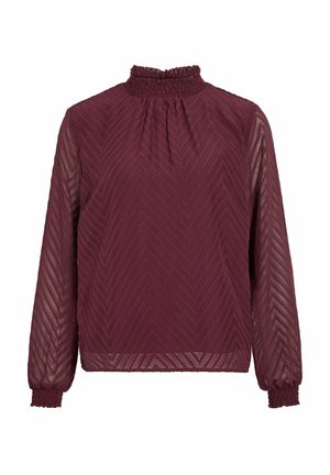 Blusa burdeos con un cuello alto y con volantes. Patrón de chevron texturizado en una tela transparente. Mangas largas con puños elásticos y corte relajado.