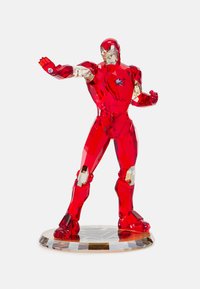 Red crystal Iron Man figurine with angular features, faceted texture, and clear accents; stands on a geometric base with a logo pattern.