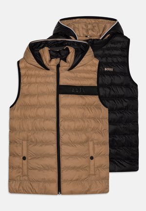 Reversible hoodie-vest in lichtbruin en zwart. Gequilt ontwerp, ritssluiting aan de voorkant, twee drukknoopzakken en logo-accenten aan beide zijden.