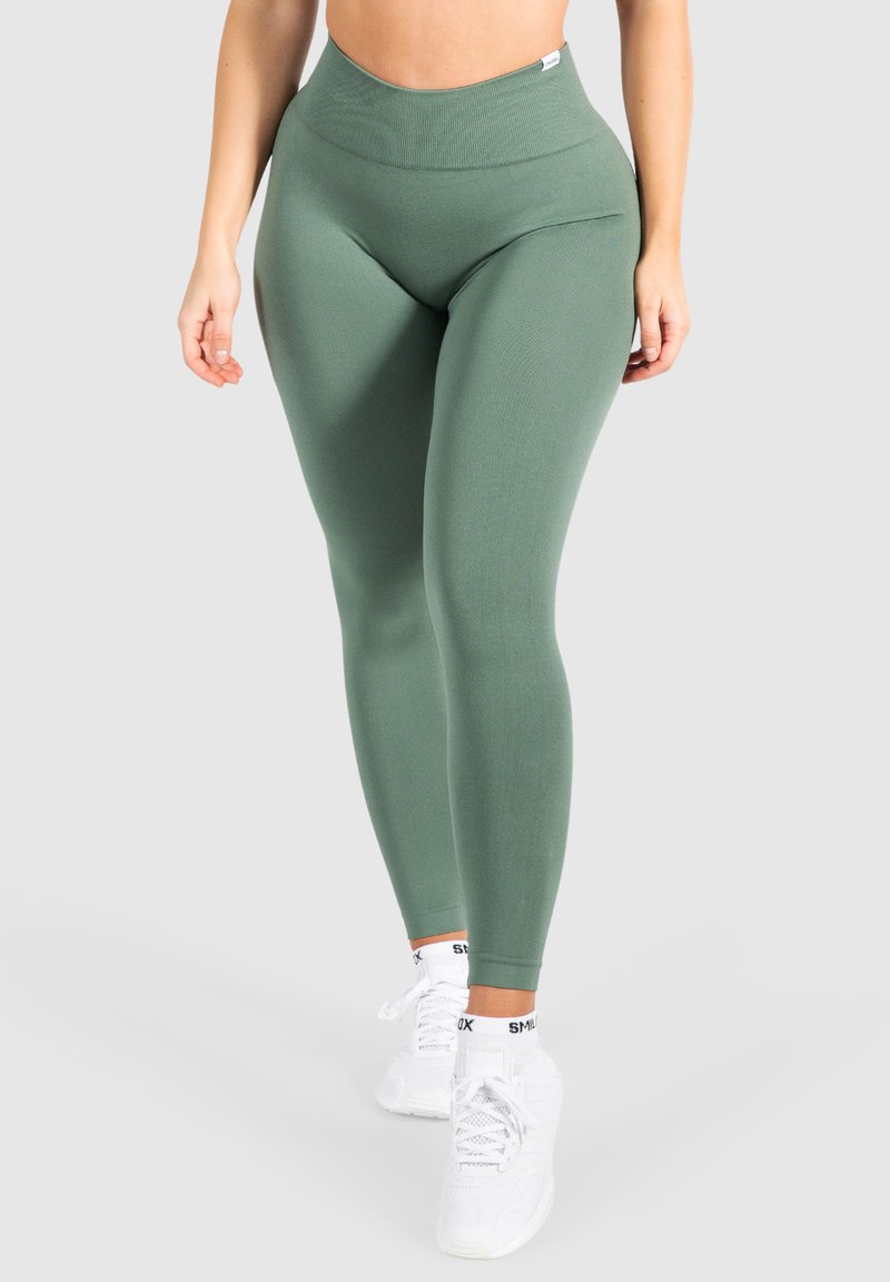 Leggings verdi a vita alta realizzati in tessuto elastico con una texture a coste, caratterizzati da un design elegante e senza motivi visibili.