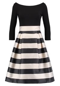 Svart avskuren klänning med trekvartsärmar, med en plisserad kjol i växlande svarta och krämfärgade breda ränder.