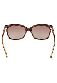 Gafas de sol de carey marrón con montura cuadrada, lentes degradados y acentos transparentes en las varillas, con brazos elegantes y afinados.