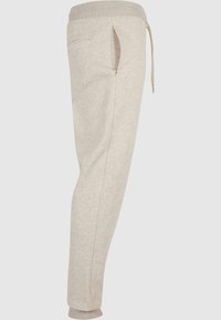 Lichtbeige sweatpants van een zachte stof. Voorzien van een tailleband met trekkoord, een zijzak en taps toelopende enkels met gebreide zomen.