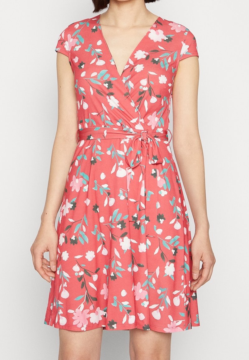 Robe portefeuille corail à motifs floraux. Manches courtes, encolure en V et taille nouée. Présente des détails de fleurs roses, bleues et noires.
