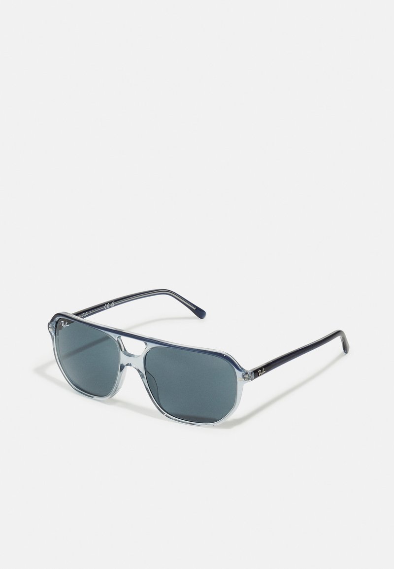 Ochelari de soare cu un cadru albastru deschis și lentile gri închise. Formă rectangulară, cu un pod gros și brațe subțiri de culoare neagră, cu branding.