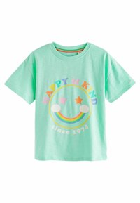 Mintgrøn T-shirt med et rundt grafik, der viser 'HAPPY & KIND', stjerner, en regnbue og 'siden 1974'. Korte ærmer, lavet af bomuldsstof.