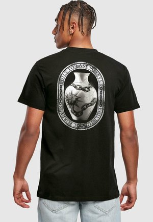 T-shirt en coton noir avec un grand graphisme gris au dos représentant un vase orné avec des chaînes et un design d'étoile. Coupe décontractée.