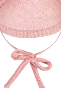 Soft pink textured baby bonnet with ribbed edge and tied bow made from matching fabric strings.