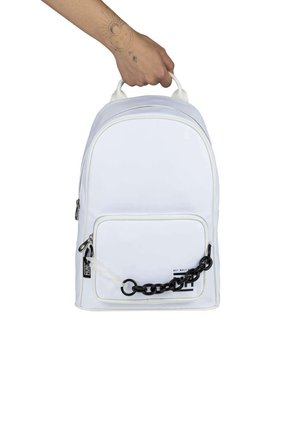 Mochila de nylon blanca con forma redondeada, asa superior, bolsillo frontal con un acento de cadena negra y un diseño minimalista.