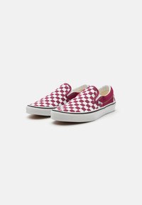 Červenobiele kárované slip-on topánky s plátenným zvrškom, gumovou podrážkou a elastickými bočnými akcentmi pre jednoduché obúvanie.