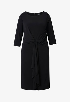 Mustapuku, jossa on kolme neljänneksen hihaa, kierretty muotoilu vyötäröllä ja kerroksellinen etukiilteen yksityiskohta. Tasainen, joustava kangas. Vetoketju takana.