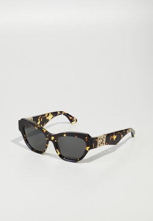 Óculos de sol tartaruga com lentes escuras; forma angular; detalhe em dourado nas hastes; acabamento brilhante; padrão distinto em preto e âmbar.