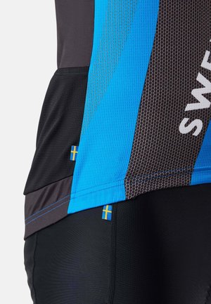 Sivukuva sinisestä ja mustasta urheilupaidasta, jossa on verkkorakenne ja pienet Ruotsin lipun merkit sivusaumassa.