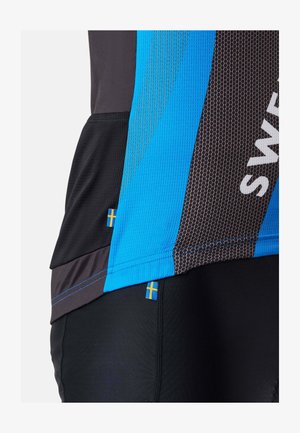 Sivukuva sinisestä ja mustasta urheilupaidasta, jossa on verkkorakenne ja pienet Ruotsin lipun merkit sivusaumassa.