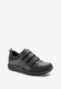 Chaussure de sport noire avec trois bandes Velcro, tige en cuir synthétique et amorti. Présente une semelle texturée et une languette au talon.
