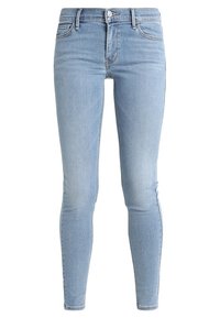 Jeans skinny azul claro confeccionados en denim, con un diseño clásico de cinco bolsillos, cierre frontal con cremallera y botón. Textura suave.