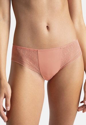 String en dentelle rose et en mesh, avec une bordure en dentelle florale au niveau de la taille et un devant en tissu lisse. Texture douce avec des détails délicats.