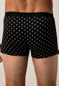 Boxer neri con un motivo a punti esagonali bianchi. Tessuto morbido con una vita elastica che mostra "JP1880." Design aderente.