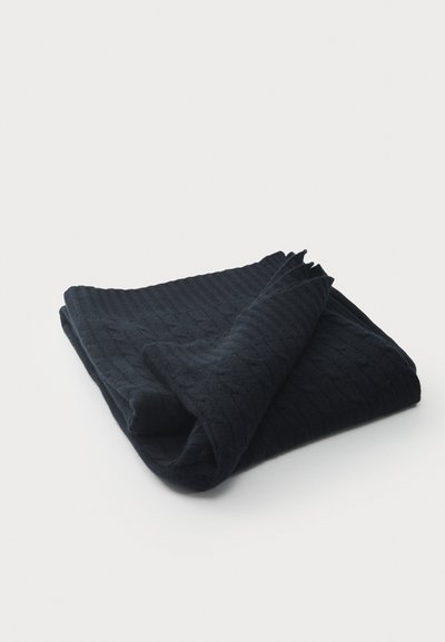 Dark navy knitted throw blanket, folded, features a textured rib pattern and soft finish. Edges are slightly frayed.