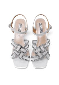 Sandali con tacco argento caratterizzati da una punta squadrata, cinghie intrecciate con accenti metallici e una delicata cinghia per la caviglia. Texture in pelle liscia.