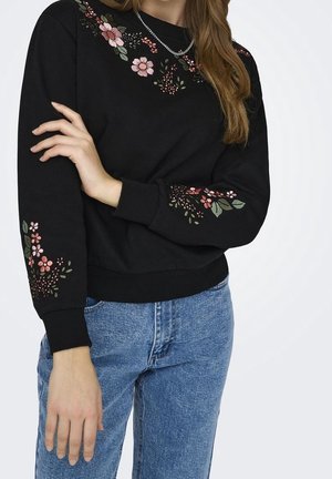 Sweatshirt noir avec broderie florale en rose et vert sur les épaules et les manches. Mélange de coton, col rond et poignets en côtes.