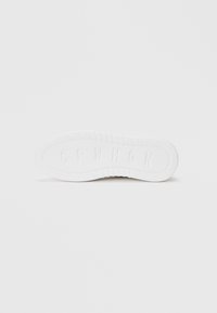 White rubber sneaker sole with textured grip pattern, featuring embossed letters "CPN" and a rounded toe design.