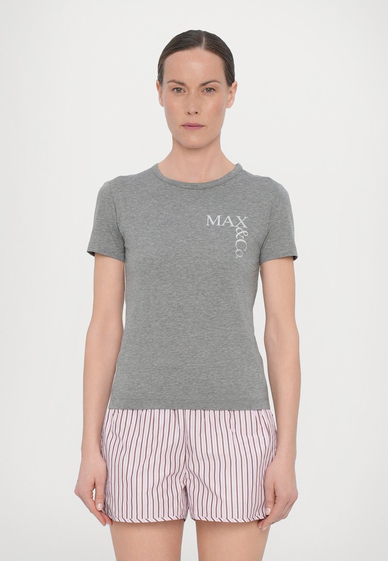 Camiseta de algodón gris con mangas cortas y cuello redondo, que presenta un logotipo impreso en blanco en el pecho; combinada con pantalones cortos a rayas rosas.