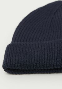 Granatowa dzianinowa czapka beanie o ryflowanej teksturze i podwiniętym mankiecie, wykonana z miękkiej mieszanki wełny lub akrylu.