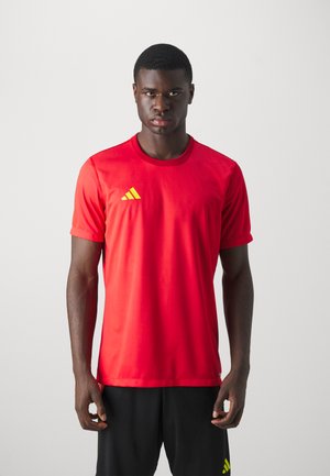 Rode sportieve T-shirt van lichtgewicht materiaal met korte mouwen. Met een gele Adidas-logo op de borst. Glad textuur, aansluitend ontwerp.
