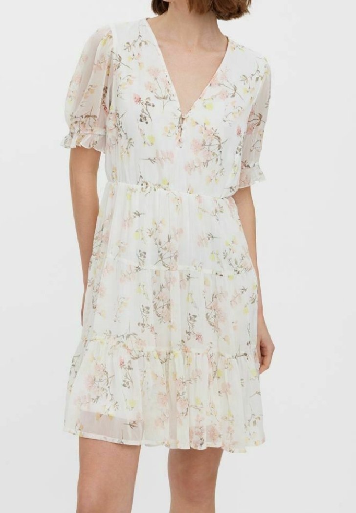 Robe courte blanche à fleurs avec un col en V, des manches bouffantes et une jupe à volants. Le tissu est léger et présente des motifs floraux pastel.