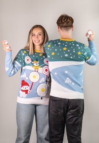 Knit sweaters feature colorful holiday motifs: a polar bear, target patterns, stars, and snowflakes. Ribbed cuffs with a light blue and yellow color scheme.