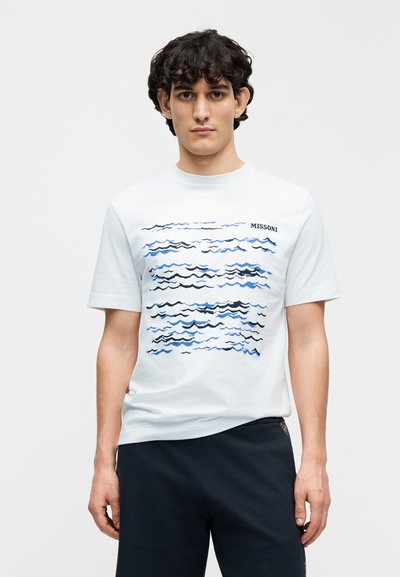 Λευκό βαμβακερό t-shirt με κυματιστό μπλε και μαύρο γραφικό σχέδιο στο μπροστινό μέρος, με το λογότυπο "MISSONI" στην πάνω δεξιά γωνία.