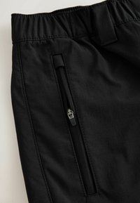 Schwarze Shorts mit elastischem Bund, seitlicher Reißverschlusstasche und glattem, leichtem Stoff mit feiner Struktur und sauberen Nahtdetails.