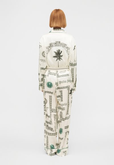 Σετ πιτζάμες από μετάξι με εκτύπωση θεματική χρήματα σε κρεμ απόχρωση, με πράσινες λεπτομέρειες. Περιλαμβάνει πουκάμισο με κουμπιά και φαρδιά παντελόνια.